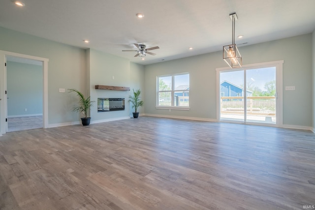 848 W S St, Upland, IN 46989 - unfurnished living room featuring wood finished floors, recessed lighting, a ceiling fan, a glass covered fireplace, and baseboards