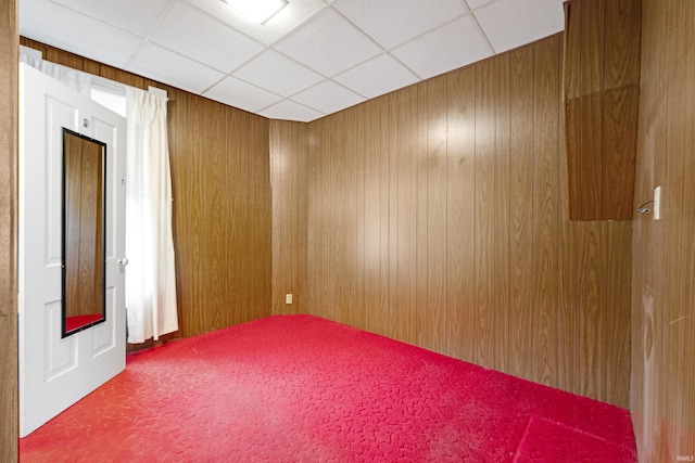 1202 S Van Buren St, Auburn, IN 46706 - unfurnished room with a drop ceiling, carpet flooring, and wood walls