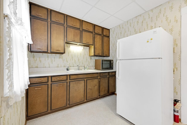 1202 S Van Buren St, Auburn, IN 46706 - kitchen with freestanding refrigerator, black microwave, wallpapered walls, a sink, and light countertops