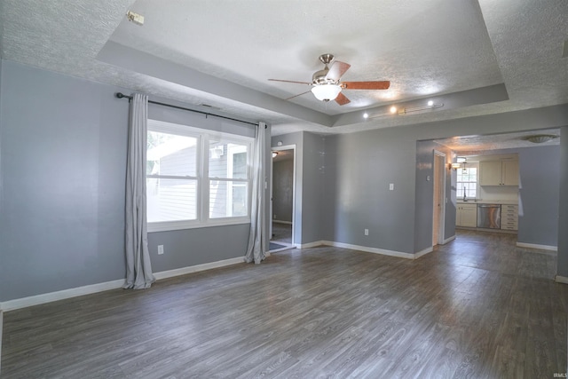52589 Lilac Rd, South Bend, IN 46628 - spare room with a raised ceiling, a textured ceiling, wood finished floors, ceiling fan, and baseboards