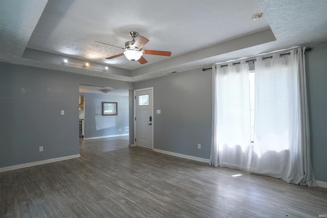 52589 Lilac Rd, South Bend, IN 46628 - empty room with a tray ceiling, baseboards, wood finished floors, ceiling fan, and a textured ceiling