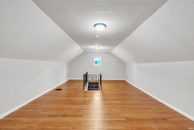 3709 Shady Ct, Fort Wayne, IN 46807 - bonus room featuring a textured ceiling, baseboards, light wood-type flooring, and lofted ceiling