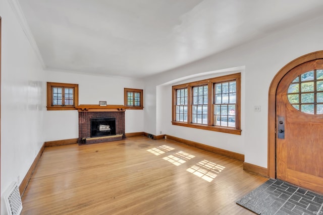 3709 Shady Ct, Fort Wayne, IN 46807 - foyer entrance featuring wood finished floors, a brick fireplace, baseboards, and crown molding