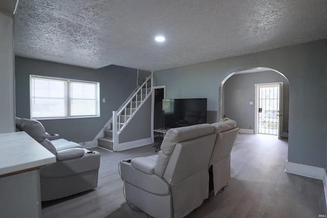 2117 Linden Ave, South Bend, IN 46628 - living room featuring arched walkways, a textured ceiling, wood finished floors, baseboards, and stairway