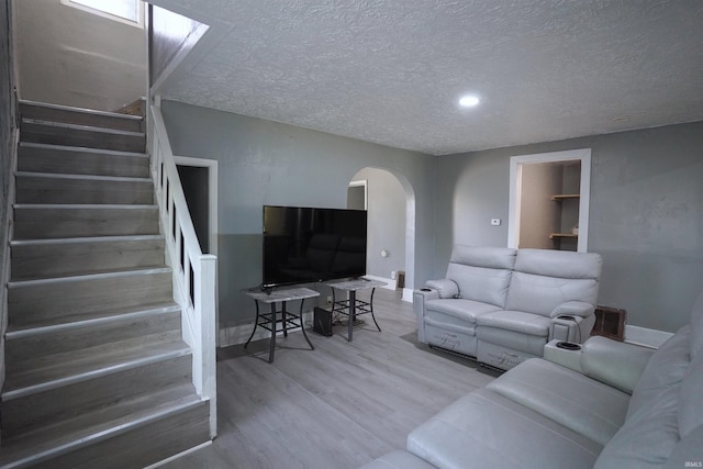 2117 Linden Ave, South Bend, IN 46628 - living room with arched walkways, wood finished floors, stairway, a textured ceiling, and baseboards