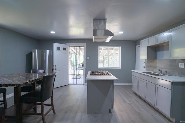 2117 Linden Ave, South Bend, IN 46628 - kitchen with appliances with stainless steel finishes, a sink, backsplash, wall chimney exhaust hood, and light countertops