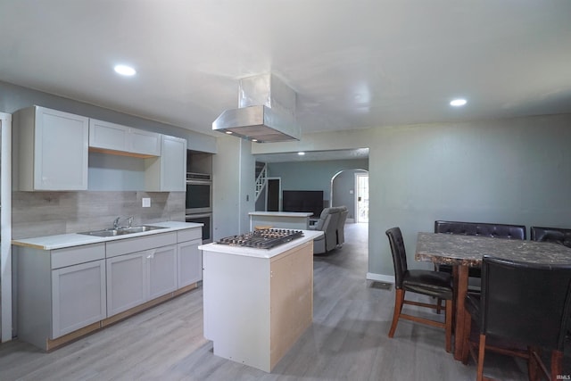 2117 Linden Ave, South Bend, IN 46628 - kitchen with island exhaust hood, a sink, appliances with stainless steel finishes, a center island, and arched walkways