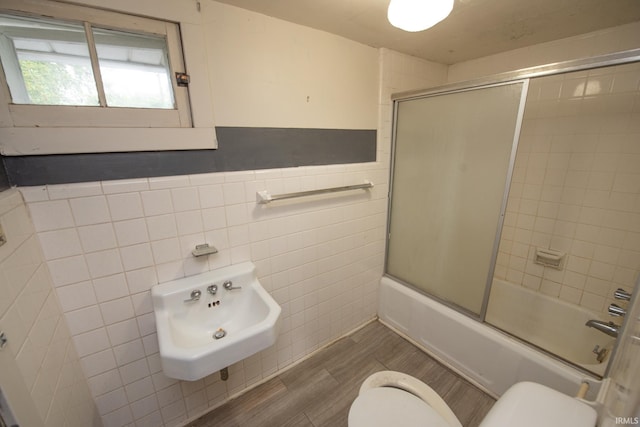 924 S Washington St, Delphi, IN 46923 - bathroom with toilet, tile walls, combined bath / shower with glass door, and wood finished floors