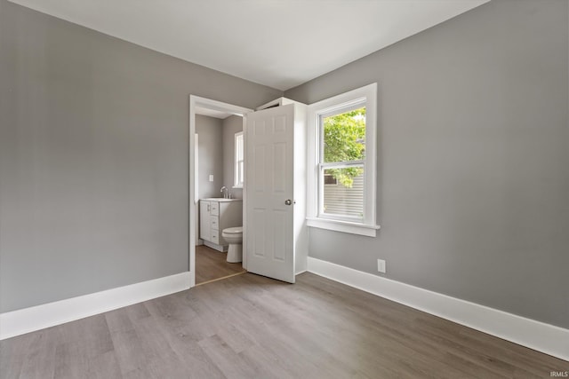 1815 E Bowman St, South Bend, IN 46613 - unfurnished bedroom with wood finished floors, baseboards, and a sink