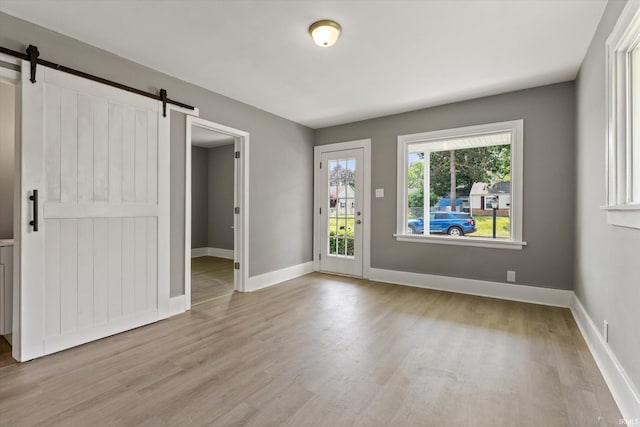 1815 E Bowman St, South Bend, IN 46613 - empty room featuring a barn door, wood finished floors, and baseboards