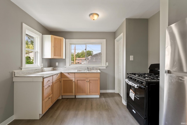 1815 E Bowman St, South Bend, IN 46613 - kitchen featuring black gas range oven, freestanding refrigerator, light wood finished floors, a sink, and light countertops