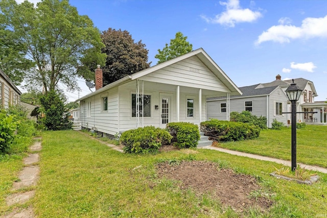 1815 E Bowman St, South Bend, IN 46613 - view of front facade with a front lawn, a chimney, and covered porch
