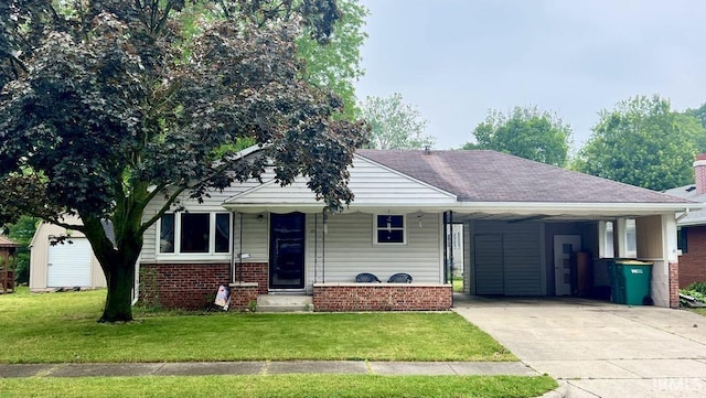 121 N Oakley Ave, Mishawaka, IN 46544 - view of front of home with concrete driveway, a carport, a front lawn, and brick siding