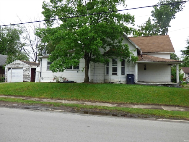302 W Freeman St, Frankfort, IN 46041 - view of front of home with an outbuilding, a front yard, a detached garage, and roof with shingles