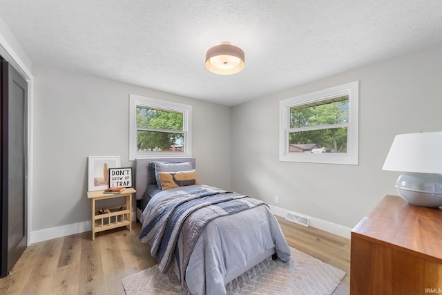 5012 Autumn Ln, Lafayette, IN 47909 - bedroom featuring multiple windows, light wood-style flooring, baseboards, and a textured ceiling