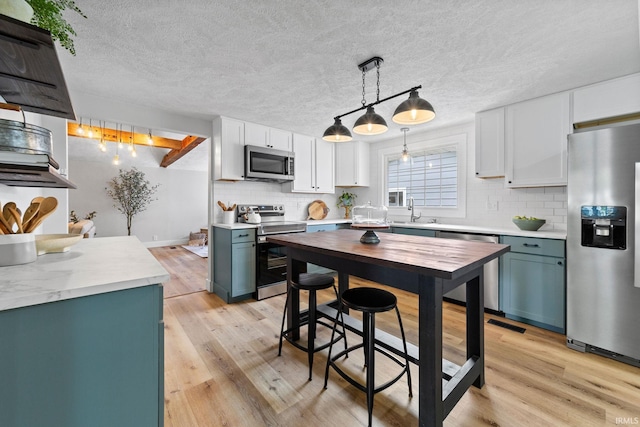 5012 Autumn Ln, Lafayette, IN 47909 - kitchen featuring appliances with stainless steel finishes, tasteful backsplash, a sink, light countertops, and a textured ceiling