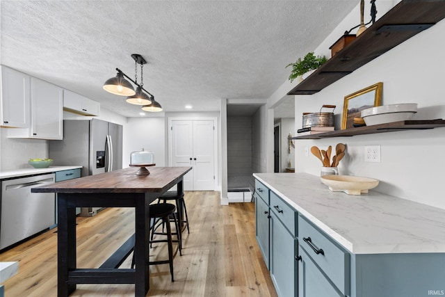 5012 Autumn Ln, Lafayette, IN 47909 - kitchen featuring open shelves, appliances with stainless steel finishes, light wood-type flooring, a textured ceiling, and white cabinets