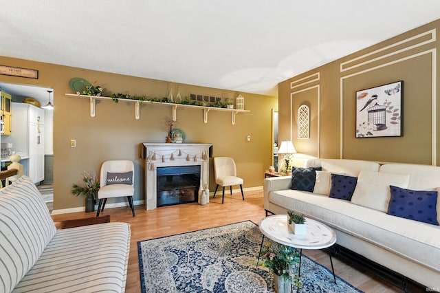 6916 Woodtrail Ct, Fort Wayne, IN 46835 - living room featuring wood finished floors, a glass covered fireplace, and baseboards