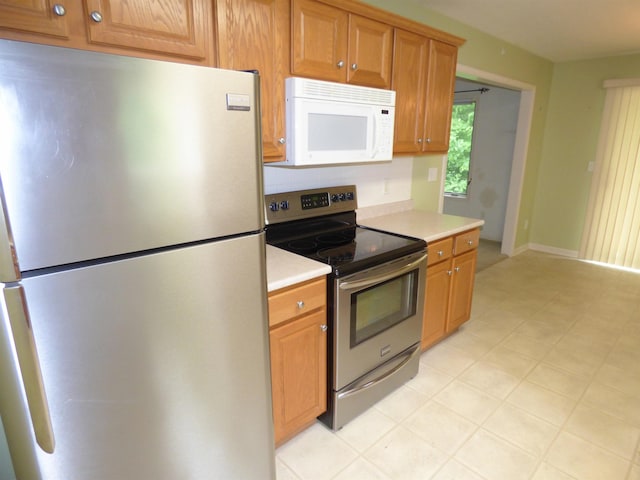 8202 Red Shank Ln, Fort Wayne, IN 46825 - kitchen with stainless steel appliances, light countertops, brown cabinetry, and tasteful backsplash