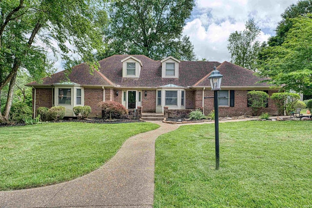 505 Wyndclyff Dr, Evansville, IN 47711 - new england style home featuring brick siding, a front yard, and roof with shingles