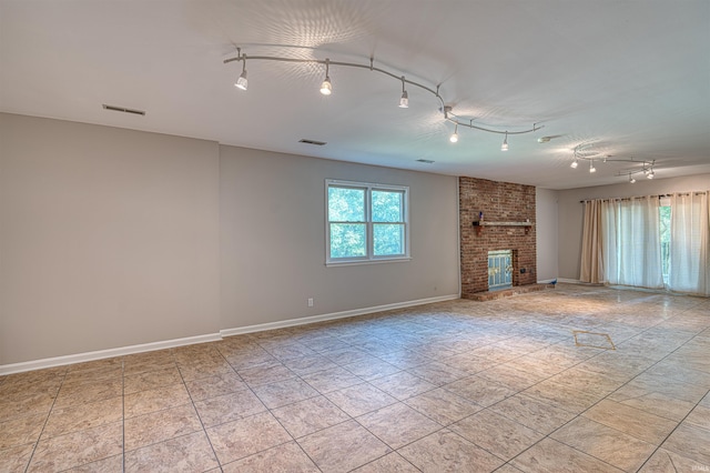 505 Wyndclyff Dr, Evansville, IN 47711 - unfurnished living room with rail lighting, a fireplace, light tile patterned floors, and baseboards