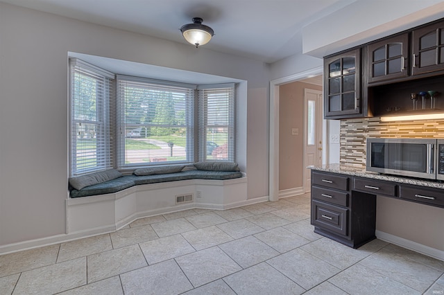 505 Wyndclyff Dr, Evansville, IN 47711 - kitchen with stainless steel microwave, decorative backsplash, healthy amount of natural light, and light tile patterned floors