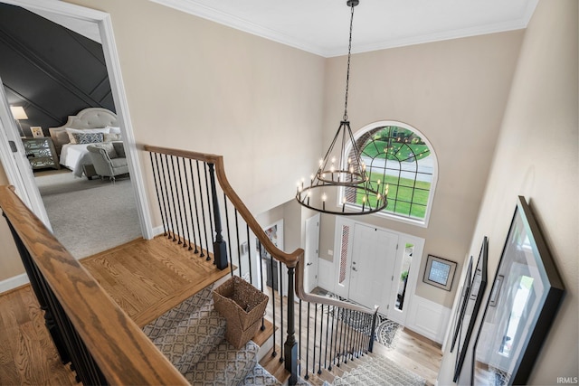 14609 Carrigan Ct, Granger, IN 46530 - entryway featuring a chandelier, wood finished floors, a towering ceiling, and crown molding