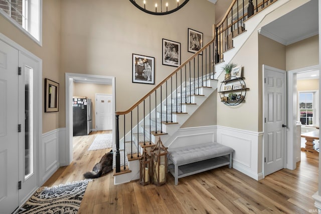 14609 Carrigan Ct, Granger, IN 46530 - foyer entrance featuring hardwood / wood-style floors, stairway, a towering ceiling, wainscoting, and ornamental molding