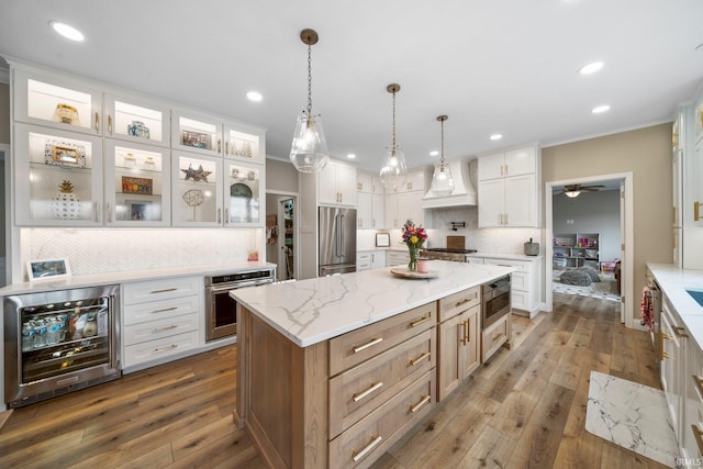 14609 Carrigan Ct, Granger, IN 46530 - kitchen with appliances with stainless steel finishes, wine cooler, custom exhaust hood, a center island, and decorative backsplash