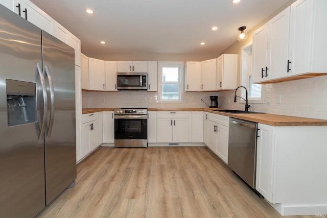400 E Center St, North Liberty, IN 46554 - kitchen with appliances with stainless steel finishes, wood counters, a sink, light wood-style flooring, and recessed lighting
