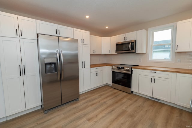 400 E Center St, North Liberty, IN 46554 - kitchen with appliances with stainless steel finishes, butcher block countertops, light wood-type flooring, recessed lighting, and white cabinets