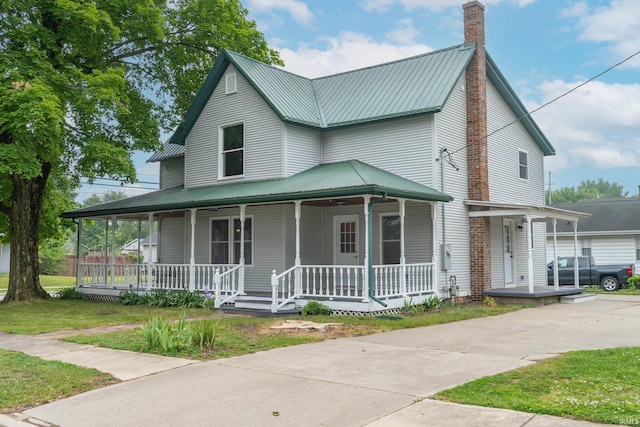 400 E Center St, North Liberty, IN 46554 - country-style home featuring covered porch, metal roof, a chimney, and a front lawn
