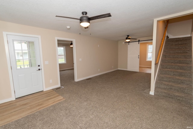 400 E Center St, North Liberty, IN 46554 - unfurnished living room featuring carpet floors, plenty of natural light, stairs, ceiling fan, and a textured ceiling