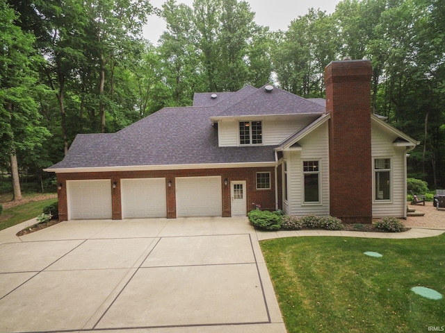 2307 Stacey Hollow Pl, Lafayette, IN 47905 - view of front of property featuring an attached garage, driveway, a chimney, a shingled roof, and a front yard