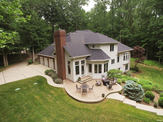 2307 Stacey Hollow Pl, Lafayette, IN 47905 - rear view of house featuring roof with shingles, a chimney, a lawn, a garage, and a patio area