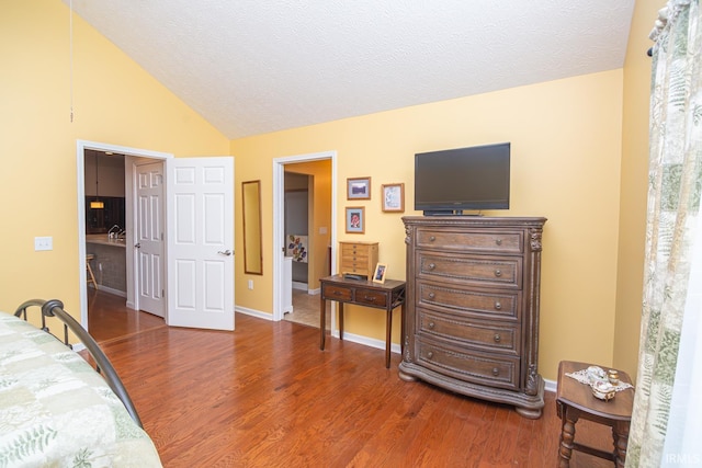 4654 Ironstone Ln, West Lafayette, IN 47906 - bedroom featuring wood finished floors, vaulted ceiling, baseboards, and a textured ceiling