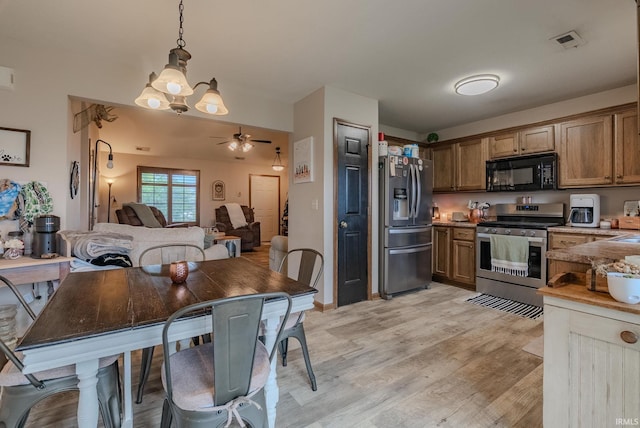 17 Chrysler Ave, Wabash, IN 46992 - kitchen with appliances with stainless steel finishes, light wood-type flooring, brown cabinetry, open floor plan, and hanging light fixtures