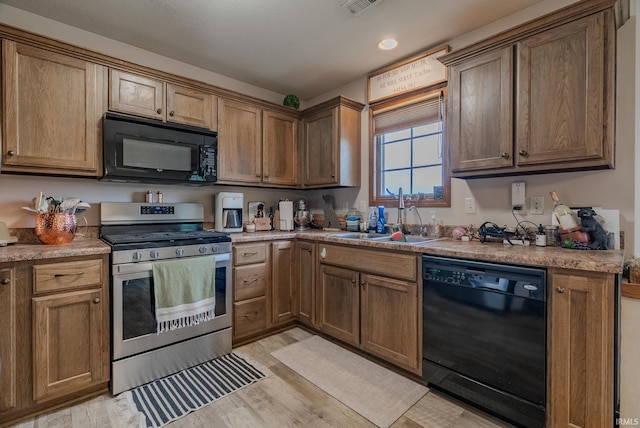 17 Chrysler Ave, Wabash, IN 46992 - kitchen featuring black appliances, a sink, light wood-style floors, and light countertops