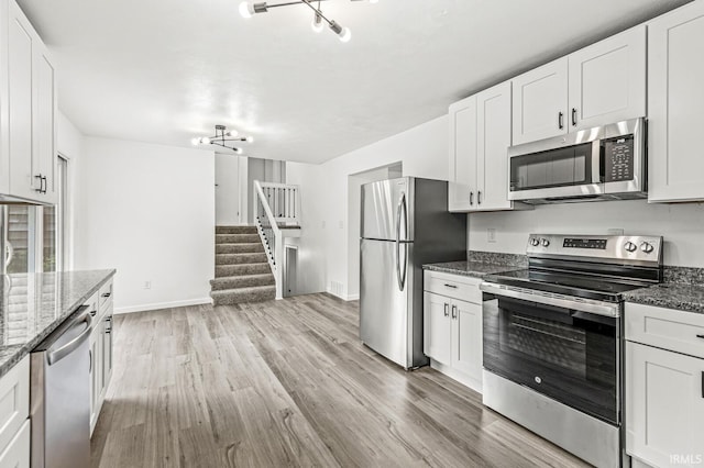 57372 Arabian Dr, Goshen, IN 46528 - kitchen with appliances with stainless steel finishes, light wood-style flooring, and white cabinetry