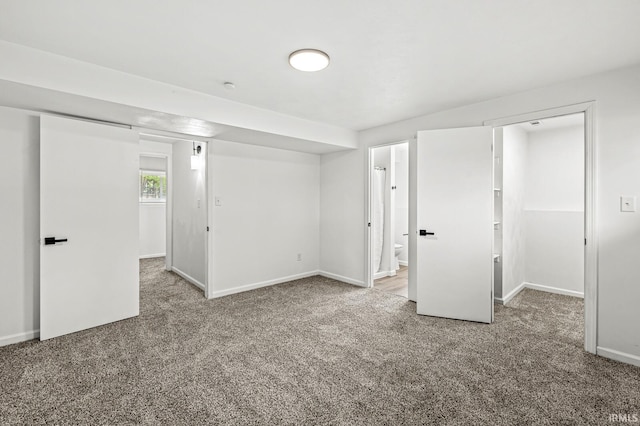 57372 Arabian Dr, Goshen, IN 46528 - unfurnished bedroom featuring carpet, baseboards, a walk in closet, and ensuite bath