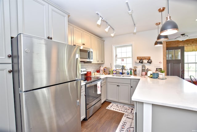 8020 N W Shafer Dr, Monticello, IN 47960 - kitchen featuring stainless steel appliances, a sink, a peninsula, light countertops, and healthy amount of natural light