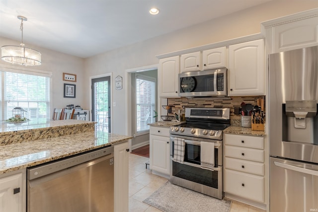 2534 Wheaton Dr, Evansville, IN 47725 - kitchen featuring appliances with stainless steel finishes, tasteful backsplash, light tile patterned flooring, a chandelier, and white cabinetry