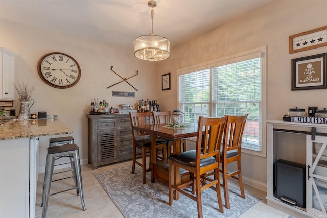 2534 Wheaton Dr, Evansville, IN 47725 - dining area featuring a chandelier, light tile patterned flooring, and baseboards