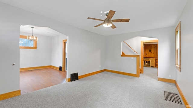 4112 Arlington Ave, Fort Wayne, IN 46807 - unfurnished room with arched walkways, a chandelier, carpet flooring, ceiling fan, and baseboards