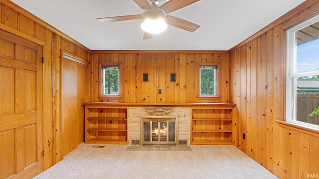 4112 Arlington Ave, Fort Wayne, IN 46807 - unfurnished living room featuring carpet floors, wooden walls, ceiling fan, and a stone fireplace