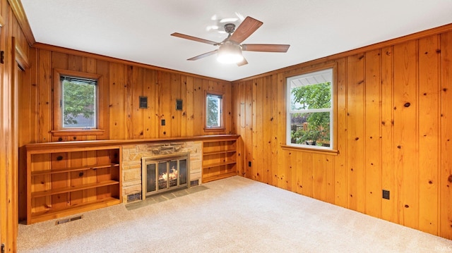 4112 Arlington Ave, Fort Wayne, IN 46807 - unfurnished living room featuring a stone fireplace, carpet, wood walls, and ceiling fan