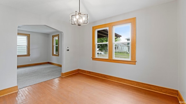 4112 Arlington Ave, Fort Wayne, IN 46807 - empty room featuring arched walkways, a chandelier, light wood-style floors, and baseboards
