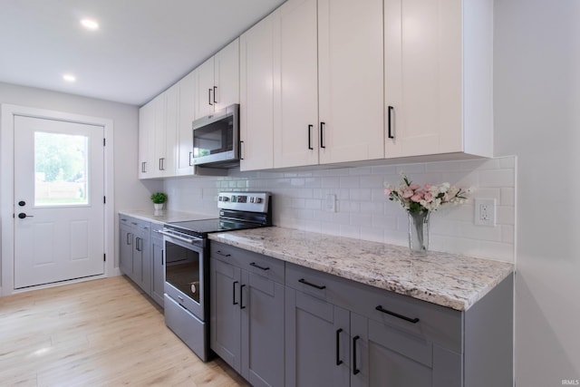 1026 S 35th St, South Bend, IN 46615 - kitchen with stainless steel appliances, white cabinetry, backsplash, light wood-type flooring, and recessed lighting