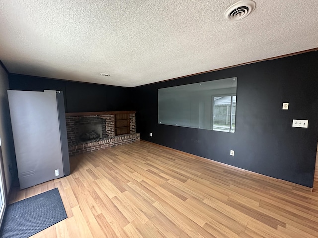 4218 Turf Ln, Fort Wayne, IN 46804 - unfurnished living room featuring wood finished floors, a textured ceiling, and a fireplace