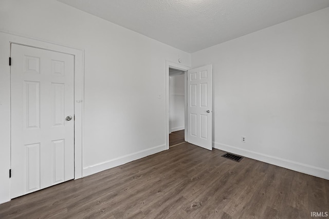 459 N Columbia St, Frankfort, IN 46041 - unfurnished bedroom featuring wood finished floors, baseboards, and a textured ceiling